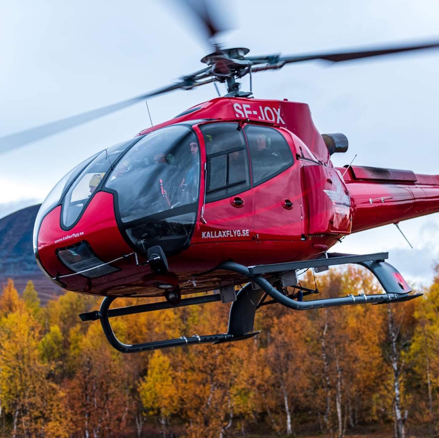 luft5 Helikopter flyger framför skog och berg